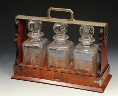 Lot 81 - A VICTORIAN WALNUT METAL MOUNTED TANTALUS with three hobnail glass decanters and wine label