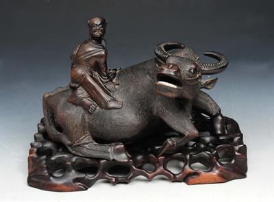 Lot 90 - A SOUTH EAST ASIAN CARVED HARDWOOD GROUP of man on the back of a water buffalo on stand