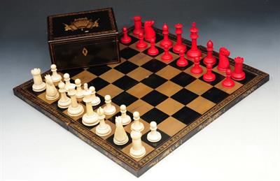 Lot 115 - AN OLD IVORY CHESS SET contained within a black lacquered box with figure decoration