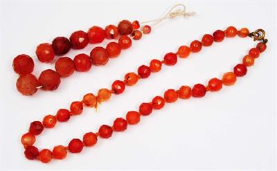 Lot 251 - TWO STRINGS OF ANTIQUE CHINESE MULTI FACETED CORNELIAN BEADS