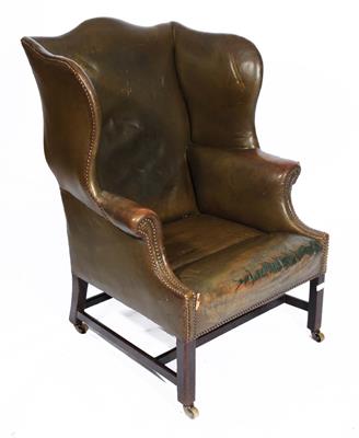 Lot 284 - A GEORGE III MAHOGANY FRAME WING ARMCHAIR upholstered in brass studded green leather on chamfered le