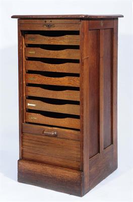 Lot 320 - AN OAK TEN DRAWER FILING CABINET by Crusader with tambour front on a plinth base