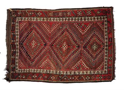 Lot 328 - A KURDISH BRICK RED GROUND RUG decorated with a diamond shaped hooked interlocking triple medallion