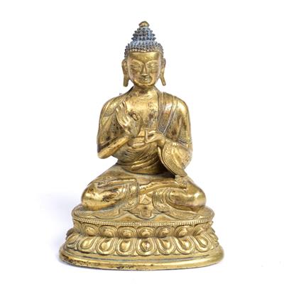 Lot 242 - A Tibetan gilt bronze figure of a seated Buddha