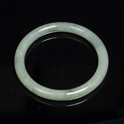 Lot 323 - A mottled green Chinese jade bangle