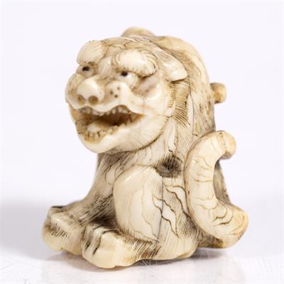 Lot 793 - A Japanese ivory netsuke of a seated tiger