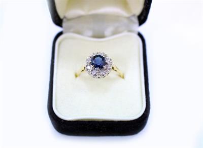 Lot 487 - AN 18 CARAT YELLOW GOLD SAPPHIRE AND DIAMOND CLUSTER RING