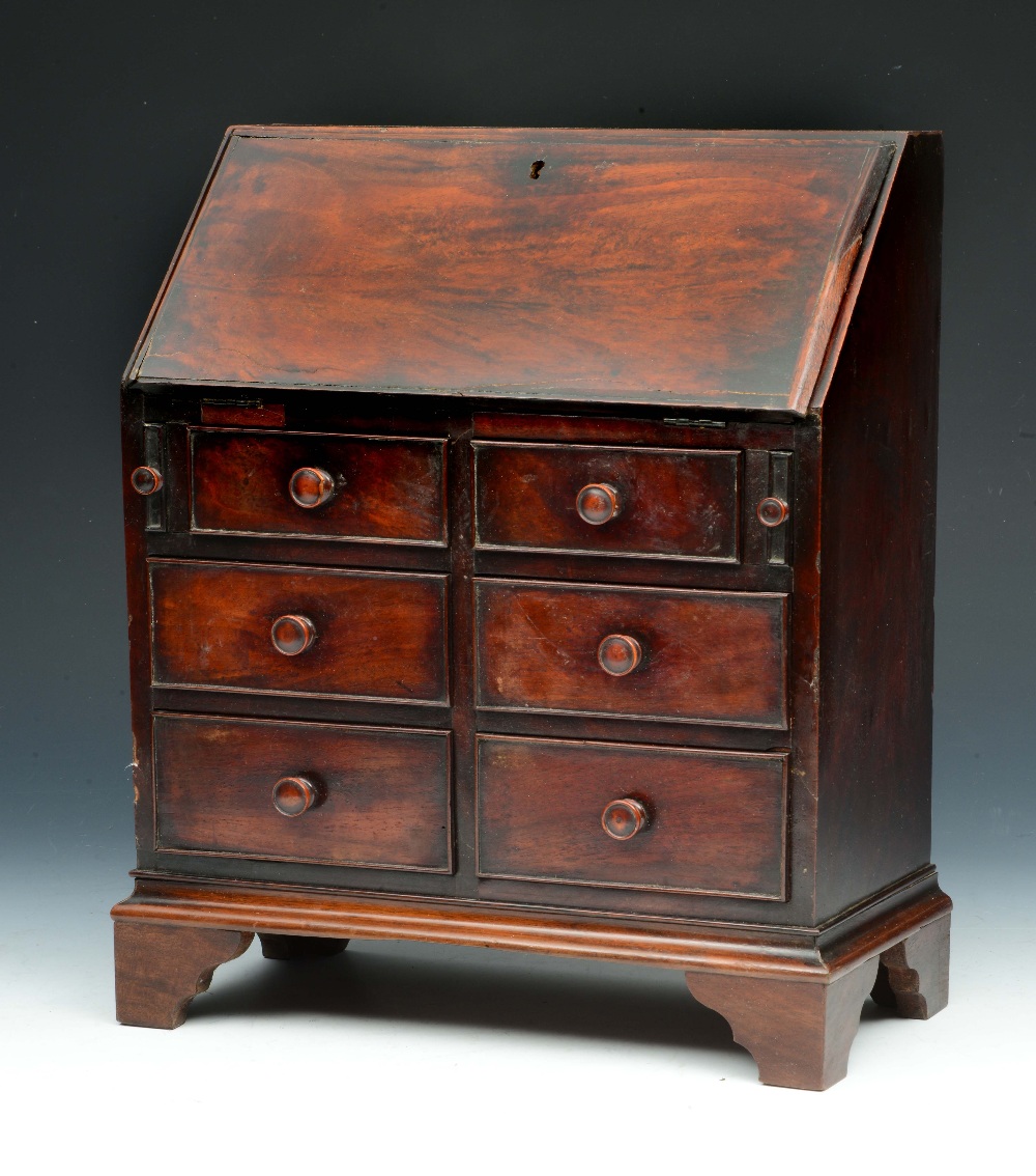 Lot 15 - A GEORGE III APPRENTICE MINIATURE MAHOGANY BUREAU with fitted interior and six drawers