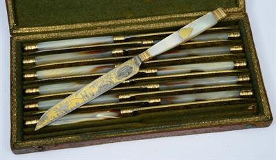 Lot 102 - A SET OF TWELVE GILT METAL AND MOTHER OF PEARL HANDLED KNIVES with blade