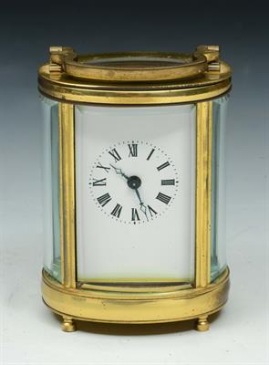 Lot 117 - A MINIATURE BRASS CASED OVAL CARRIAGE TIMEPIECE with white enamel dial and Roman numerals