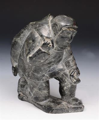 Lot 283 - AN INUIT SOAPSTONE CARVING of a hunter with seal upon his back