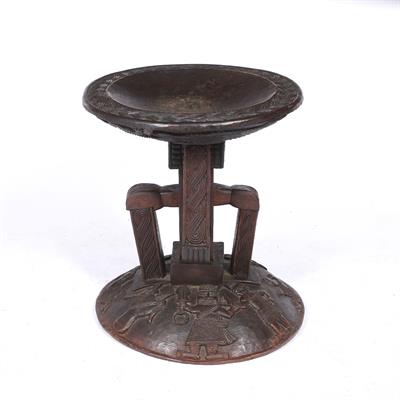 Lot 419 - AN AFRICAN CARVED WOODEN TRIBAL STOOL with circular top and raised figure decoration