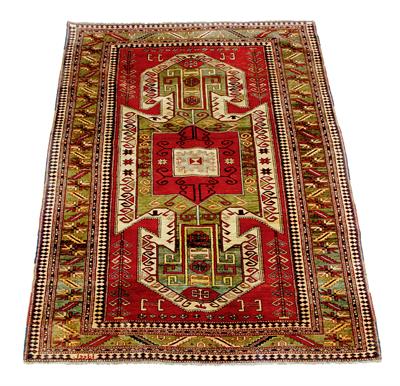 Lot 17 - A RED GROUND KAZAK DESIGN RUG with large central geometric decoration within a multiple banded borde