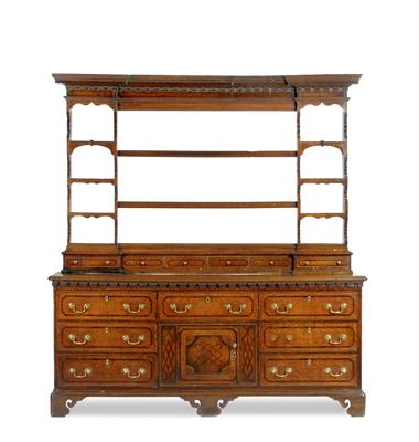 Lot 50 - A GEORGE III NORTH COUNTRY OAK DRESSER the inverse breakfront plate rack surmounted by a cornice wit