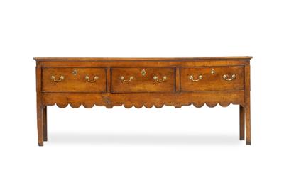 Lot 130 - A GEORGE III FRUITWOOD DRESSER BASE fitted with three drawers with brass swan neck handles having sh