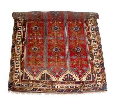 Lot 160 - A WEST TURKISH RED GROUND RUG with three bands of stylised floral decoration within a triple banded