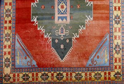 Lot 246 - A LARGE TURKISH WINE GROUND CARPET