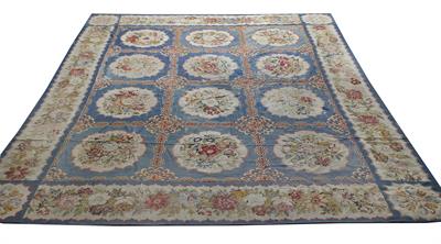 Lot 262 - AN ENGLISH BLUE GROUND NEEDLEWORK CARPET centrally decorated with twelve floral cartouches