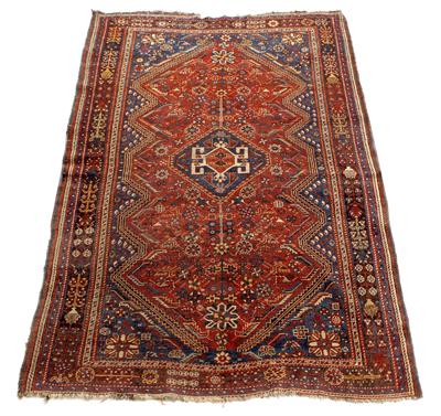 Lot 426 - A QASHQAI DARK RED GROUND RUG with a central hooked medallion within a multiple border