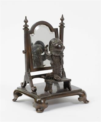 Lot 437 - A HUMOROUS CONTINENTAL BRONZE ORNAMENT in the form of a dog seated at a cheval mirror wearing a ladi