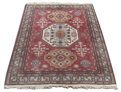 Lot 485 - A MID 20TH CENTURY MIDDLE EASTERN RED AND GREEN GROUND RUG with a multiple banded border