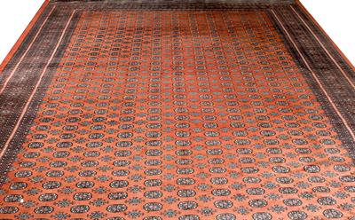 Lot 545 - A MID TO LATE 20TH CENTURY PAKISTANI RED GROUND CARPET with eleven rows of  guls and a multiple band