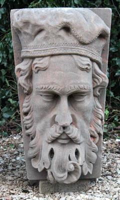 Lot 621 - A LARGE CARVED SANDSTONE KEY STONE decorated with a mask of a bearded man with soft cap 41cm wide x