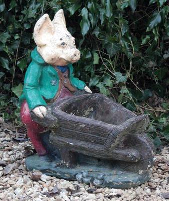 Lot 660 - A PAINTED CAST CONCRETE PIG with a wheelbarrow