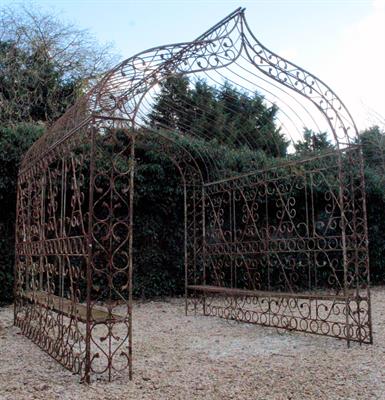 Lot 683 - A WROUGHT IRON ROSE ARCH with scroll decoration to the end and side panels and with slatted benches