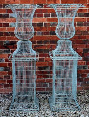 Lot 691 - A PAIR OF WIREWORK URNS of narrow campana form and both standing on square section plinth bases 62cm