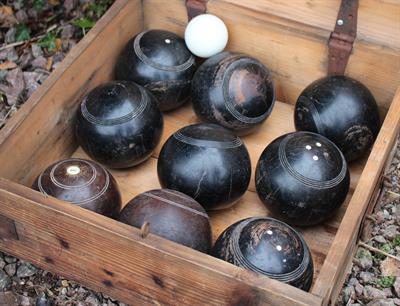 Lot 718 - A COMPOSITE LAWN BOWLS SET in a pine box