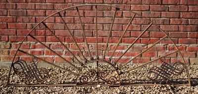 Lot 728 - A HALF ROUND WROUGHT IRON ARCHITECTURAL PANEL with radiating bars and diaper decoration 174cm wide x