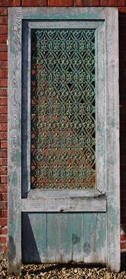 Lot 739 - AN OLD OAK DOOR with green painted pierced cast iron panel