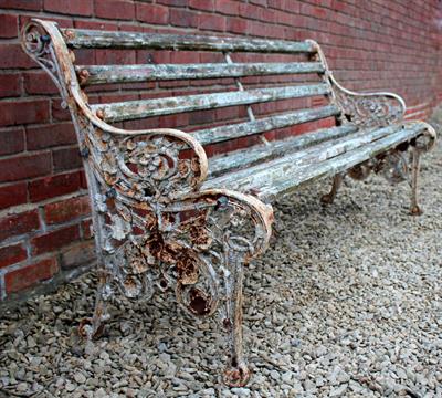 Lot 741 - A VICTORIAN CAST IRON GARDEN BENCH with floral decorated pierced ends and slatted back and seat 181c