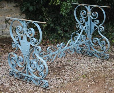 Lot 743 - AN ANTIQUE BLUE PAINTED WROUGHT IRON TABLE BASE with scroll decoration and heraldic shield mounted e