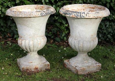 Lot 762 - A PAIR OF OLD WHITE PAINTED CAST IRON GARDEN URNS of campana form with fluted rims