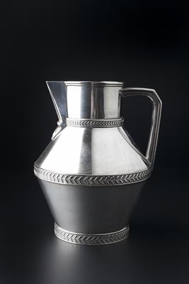 Lot 255 - Manner of Christopher Dresser (British, 1834-1904)
Silvered metal jug
with foliate motif bands
17cm