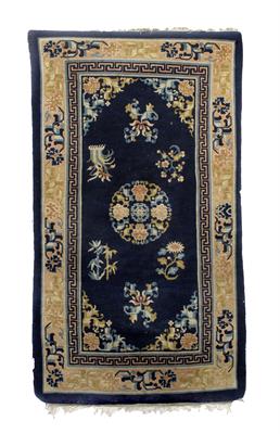 Lot 101 - A Chinese blue ground rug with central foliate decoration