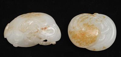 Lot 239 - Two Chinese white and rust tinted jade pebbles