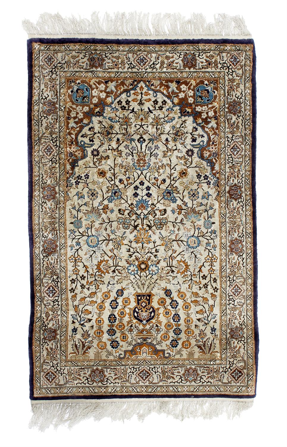 Lot 711 - A silk ivory ground Persian rug
