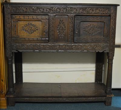 Lot 32 - A 17th Century style carved oak livery cupboard