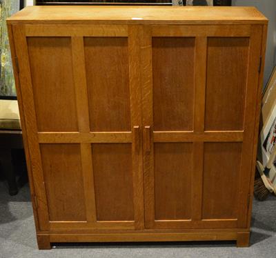 Lot 112 - A Cotswold style oak cupboard in the manner of Heals