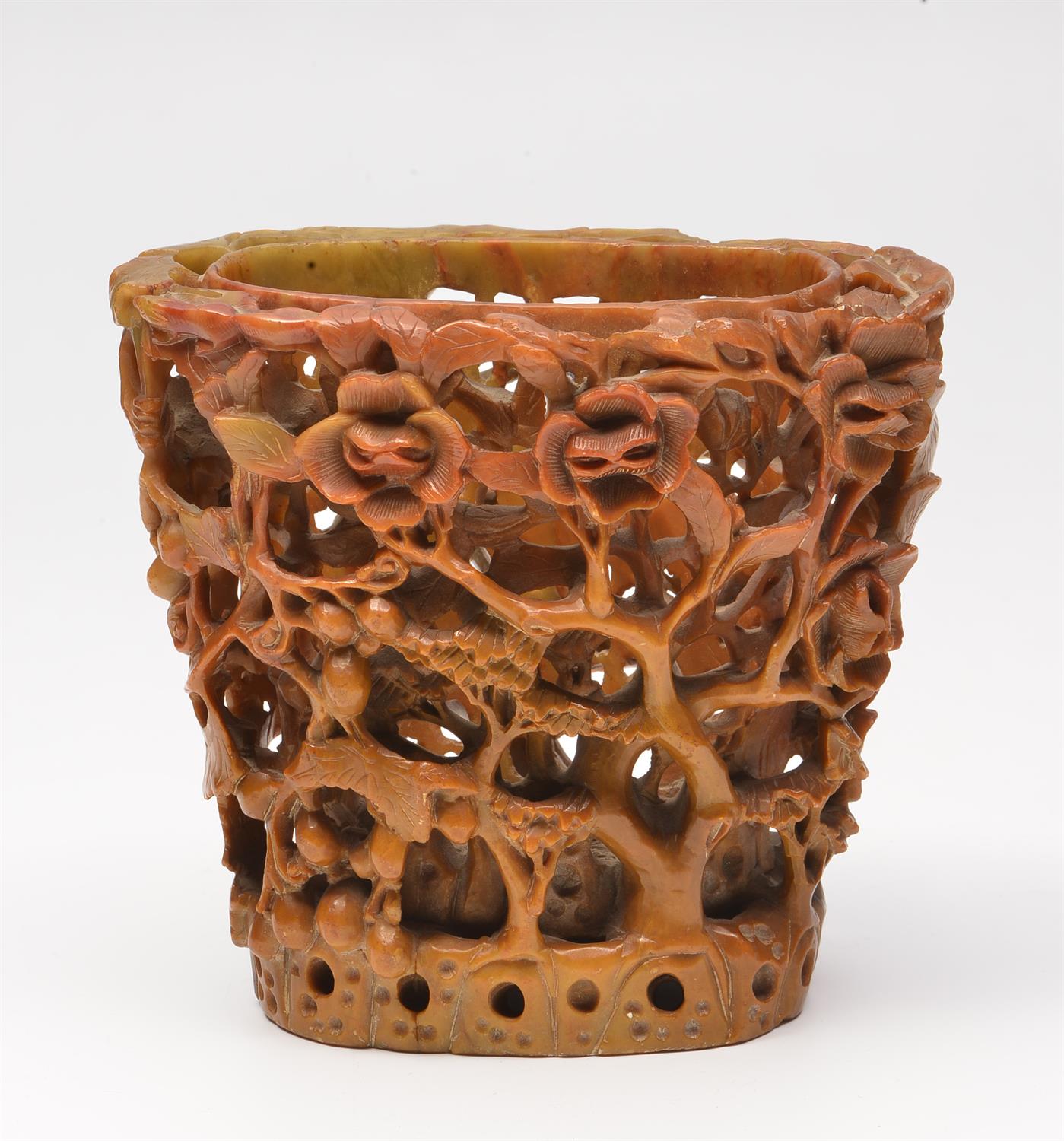 Lot 69 - A CHINESE CARVED SOAPSTONE BRUSH POT of open work form decorated with magnolia and fruit