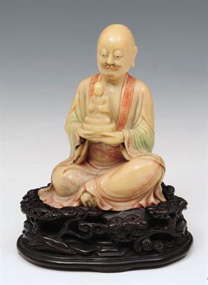 Lot 123 - A CHINESE SOAPSTONE LOHAN holding a smaller buddha in his hands