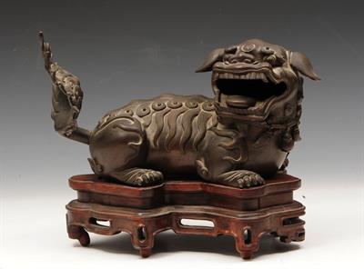 Lot 125 - A CHINESE BRONZE KYLIN with head turned to side and raised tail on original hardwood stand