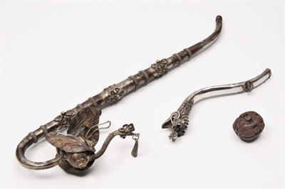 Lot 235 - A CHINESE CARVED COQUILLA NUT carved with pine trees and a Chinese silver opium pipe and one other