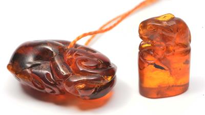 Lot 240 - A CHINESE CARVED AMBER PENDANT in the form of a puppy and a Chinese amber seal mounted with a hare