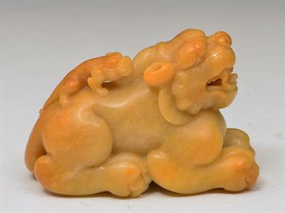 Lot 483 - A CHINESE  MOTTLED PALE YELLOW AND BROWN JADE CARVING of a mythological beast/kylin seated four