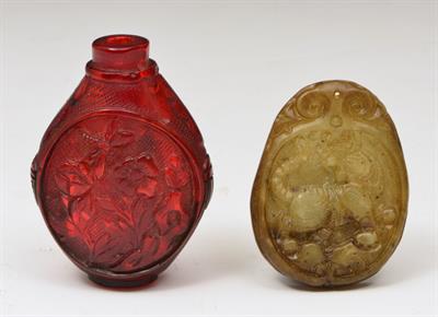 Lot 534 - A CHINESE RED AMBEROID SNUFF BOTTLE of flattened oviform decorated panels of flowers and sides with