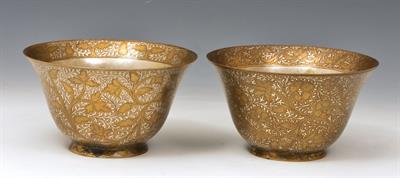 Lot 545 - A PAIR OF INDO-PERSIAN SILVERED AND BRONZED METAL TAPERING BOWLS with scrolling foliage